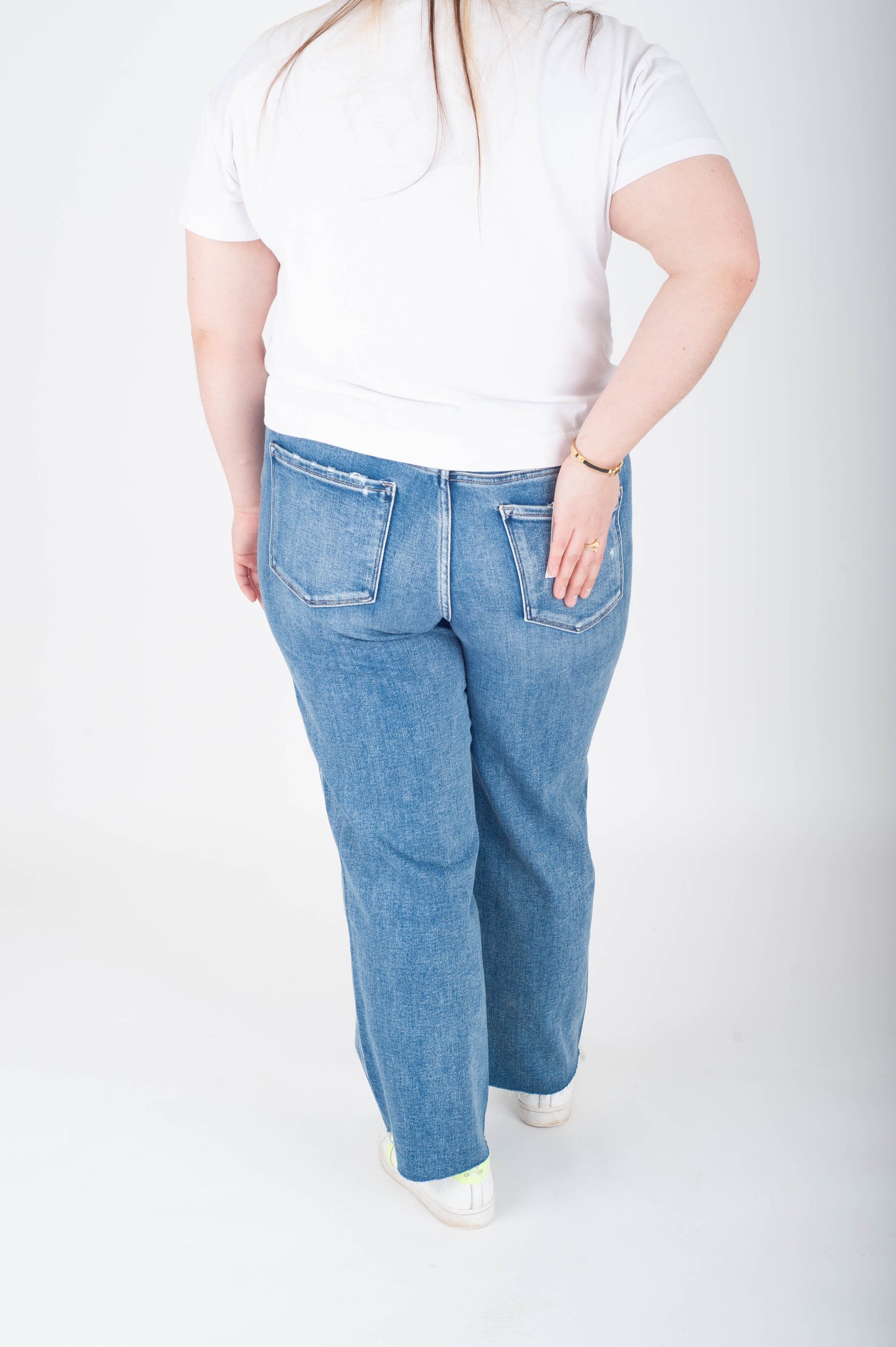Person wearing a white t-shirt and blue jeans on a white background