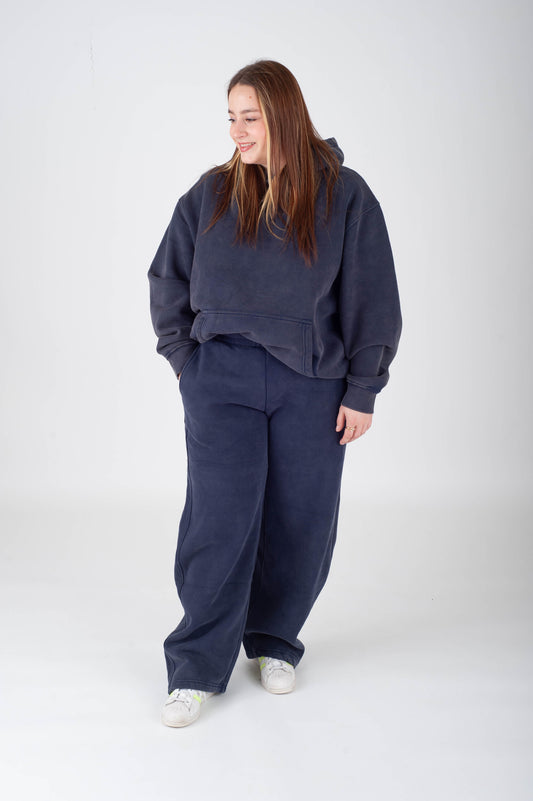 Person wearing a navy blue tracksuit on a white background