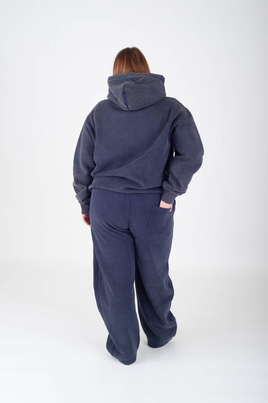 Person wearing a navy blue tracksuit on a white background