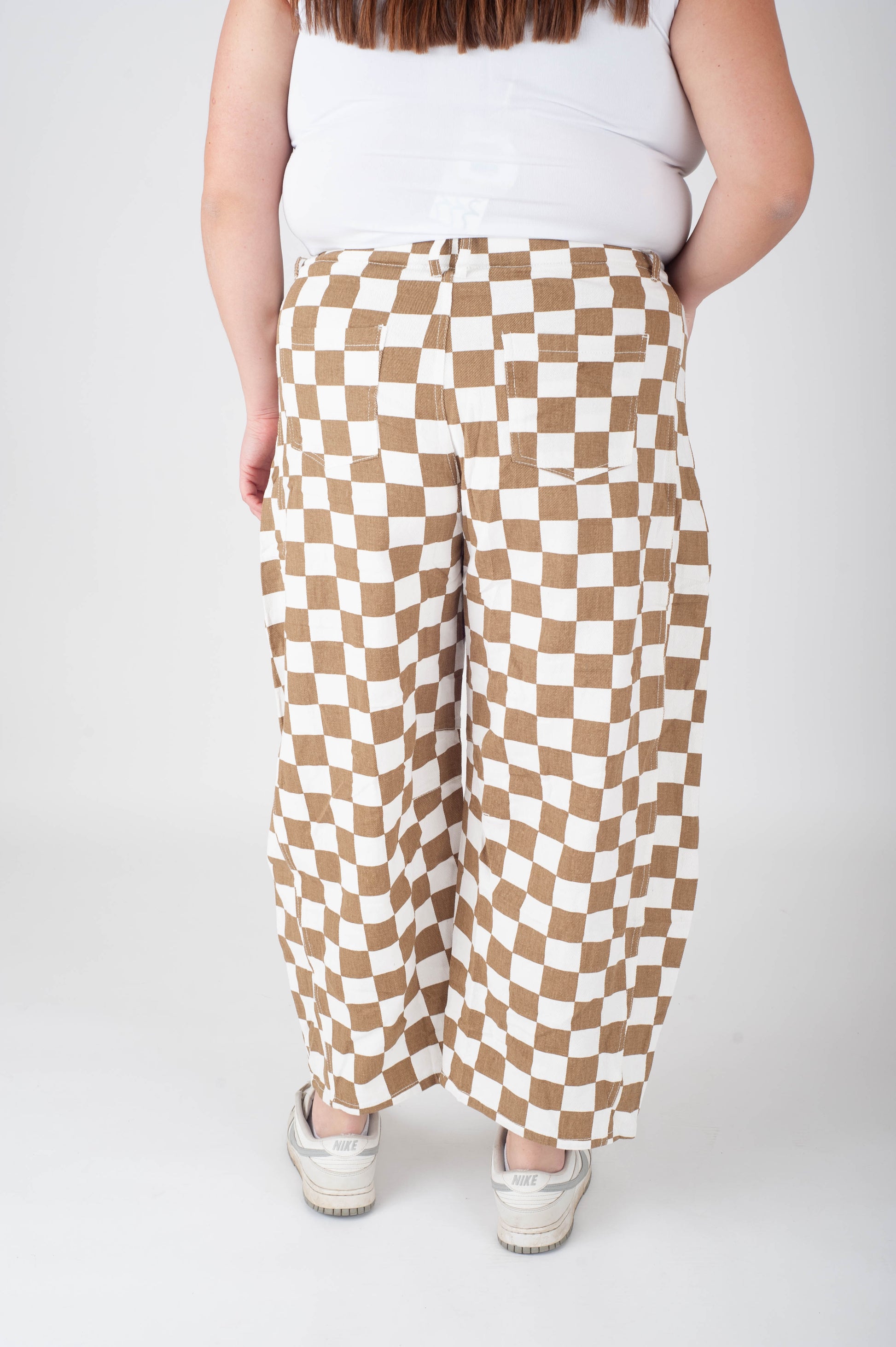 Person wearing checkered pants on a plain background