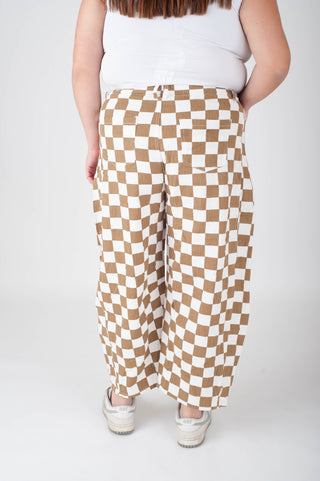 Person wearing checkered pants on a plain background