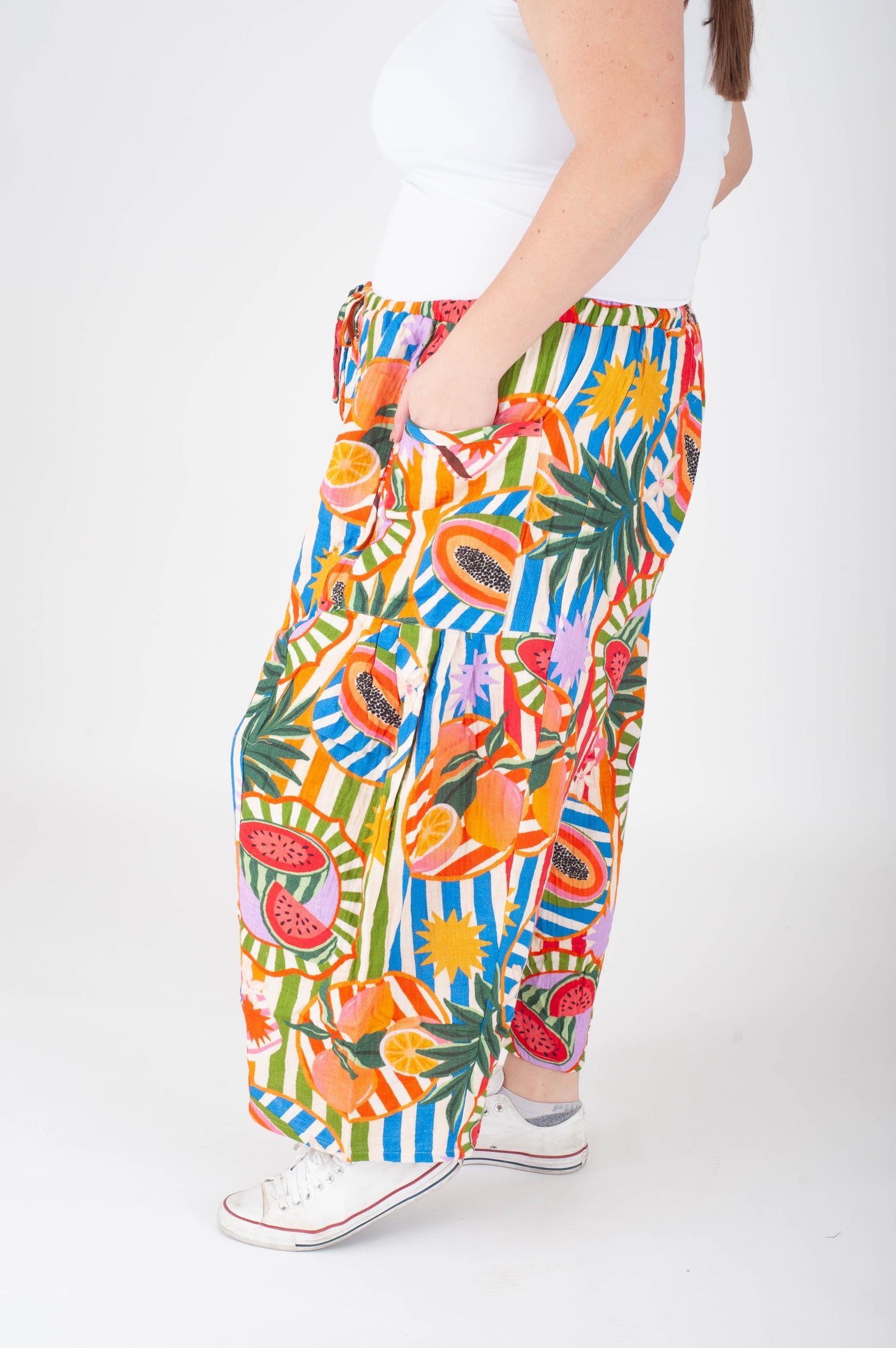 Colorful tropical patterned pants worn by a person on a white background