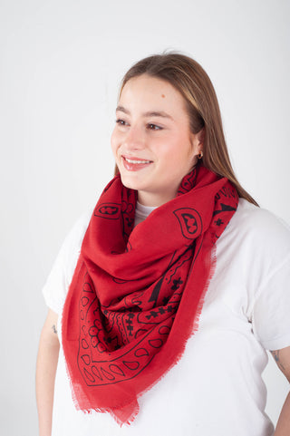 Person wearing a red scarf with black patterns on a white background