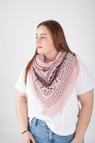 Woman wearing a pink patterned scarf on a white background