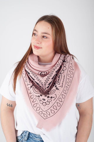 Woman wearing a pink patterned scarf on a white background