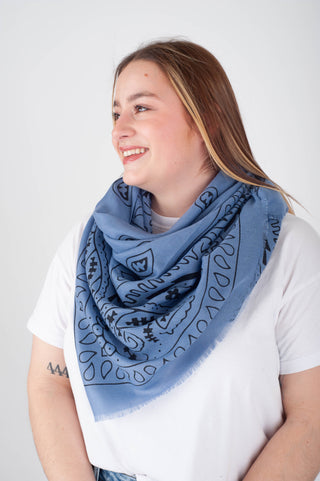 Woman wearing a blue patterned scarf on a white background