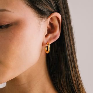 women wearing a round gold hoop earring