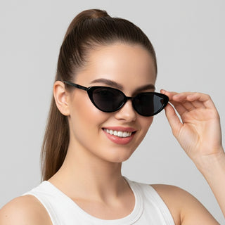 Woman wearing black sunglasses against a gray background