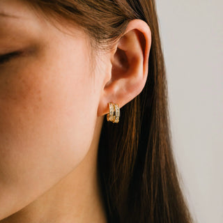 Women wearing a pair of diamond double hood earrings. 