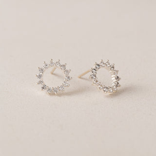 Pair of silver hoop earrings with diamonds on a neutral background