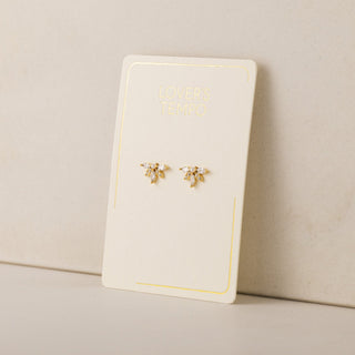 Gold bee-shaped earrings on a 'Lover's Tempo' branded card against a beige background