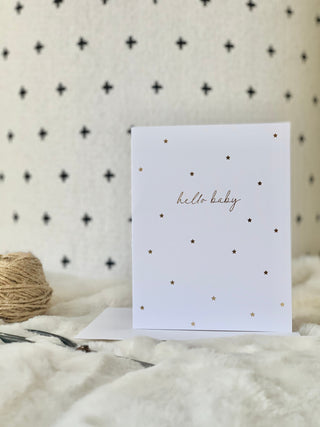 Greeting card with 'hello baby' text on a textured surface