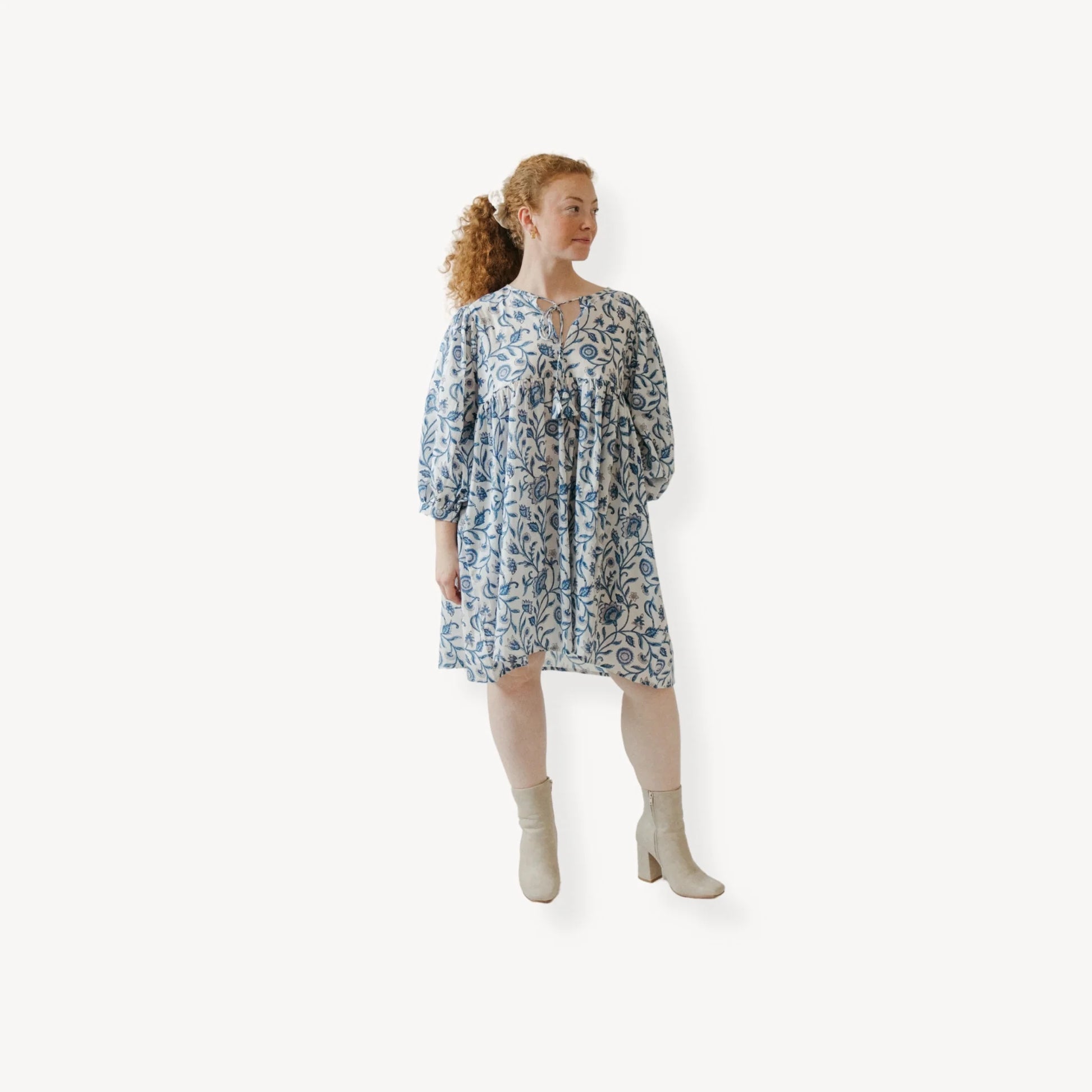 Woman wearing a patterned dress on a white background