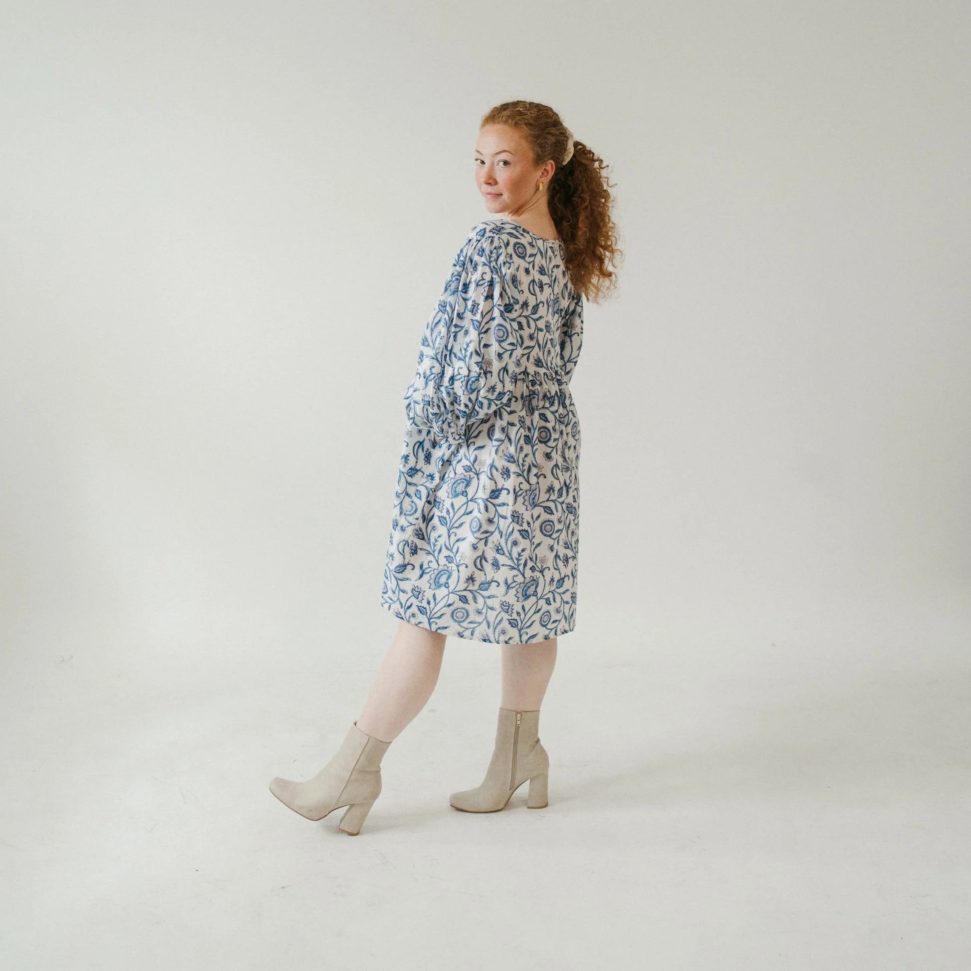 Woman wearing a floral dress on a plain background