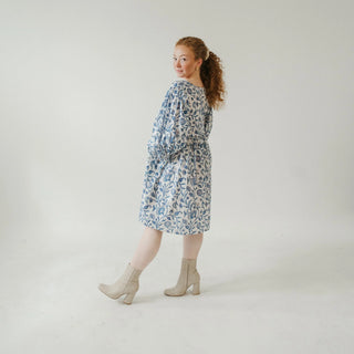 Woman wearing a floral dress on a plain background