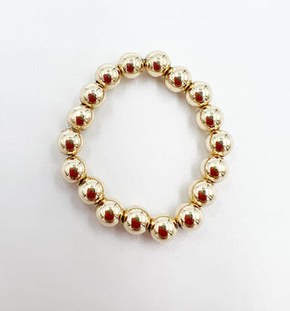 Gold beaded ring on a white textured background