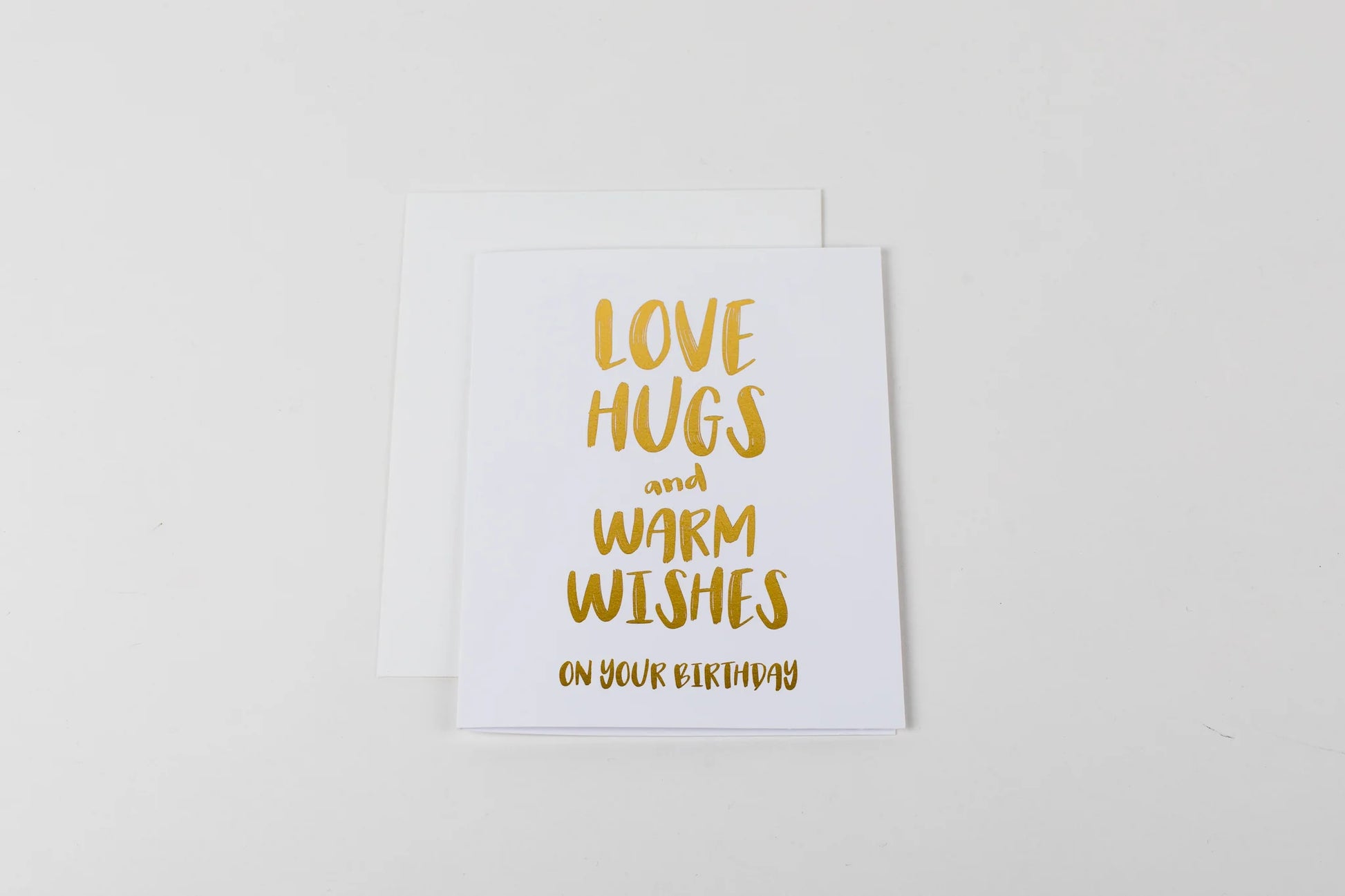 Greeting card with 'Love hugs and warm wishes on your birthday' text on a white background