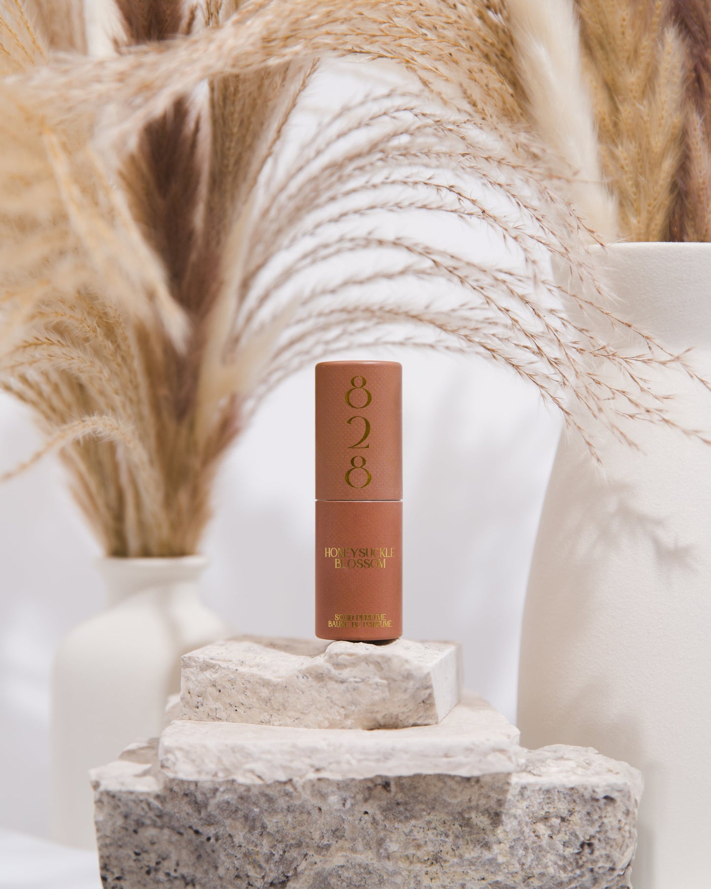 Cosmetic perfume with '828' branding on a stone surface with decorative elements in the background