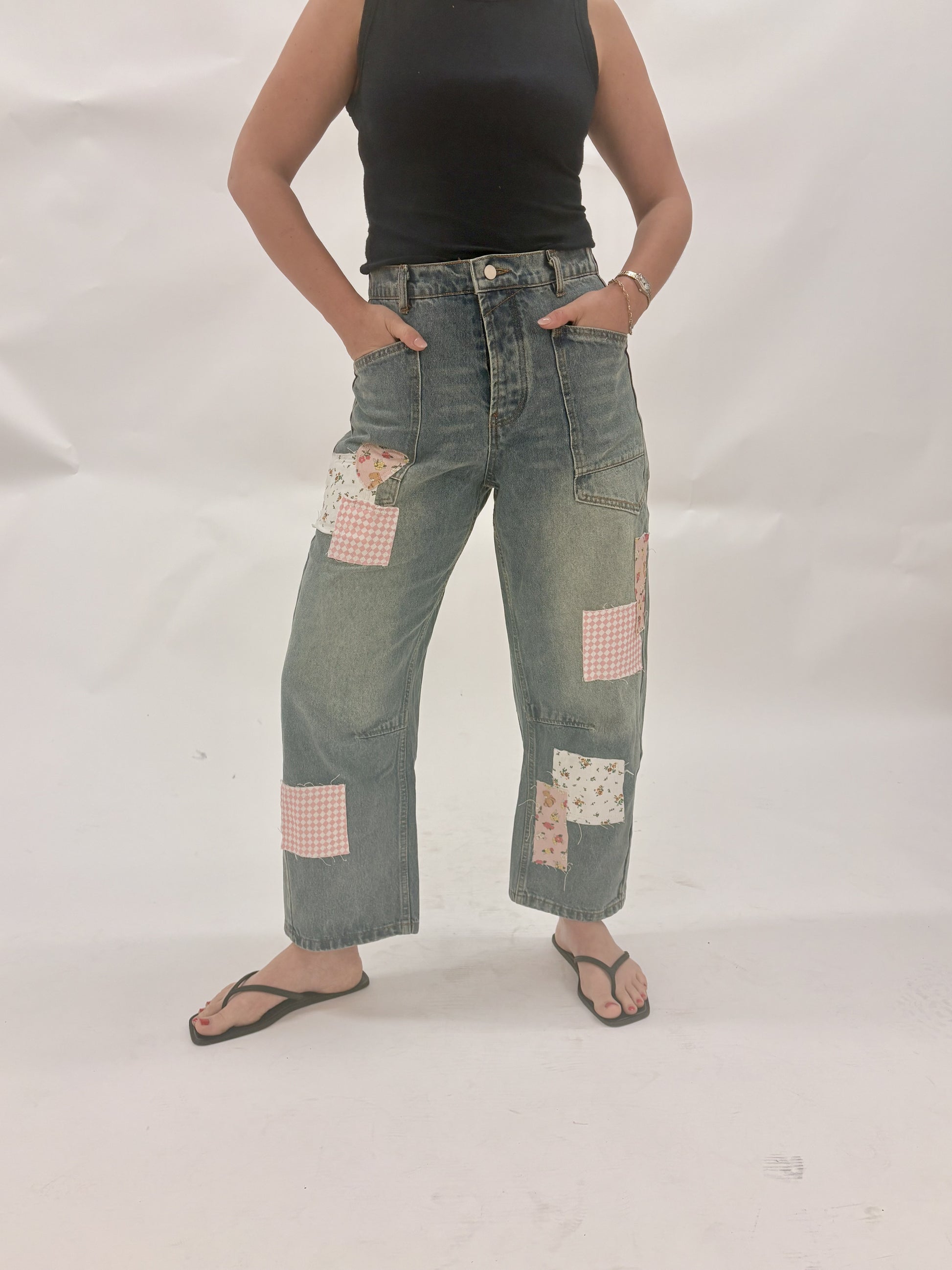Person wearing patchwork jeans on a white background