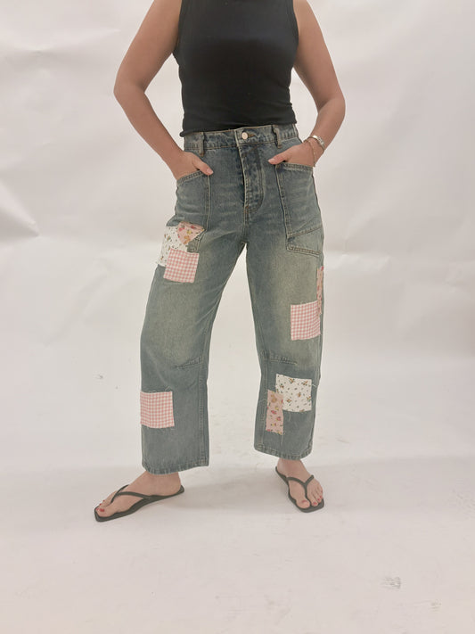 Person wearing patchwork jeans on a white background