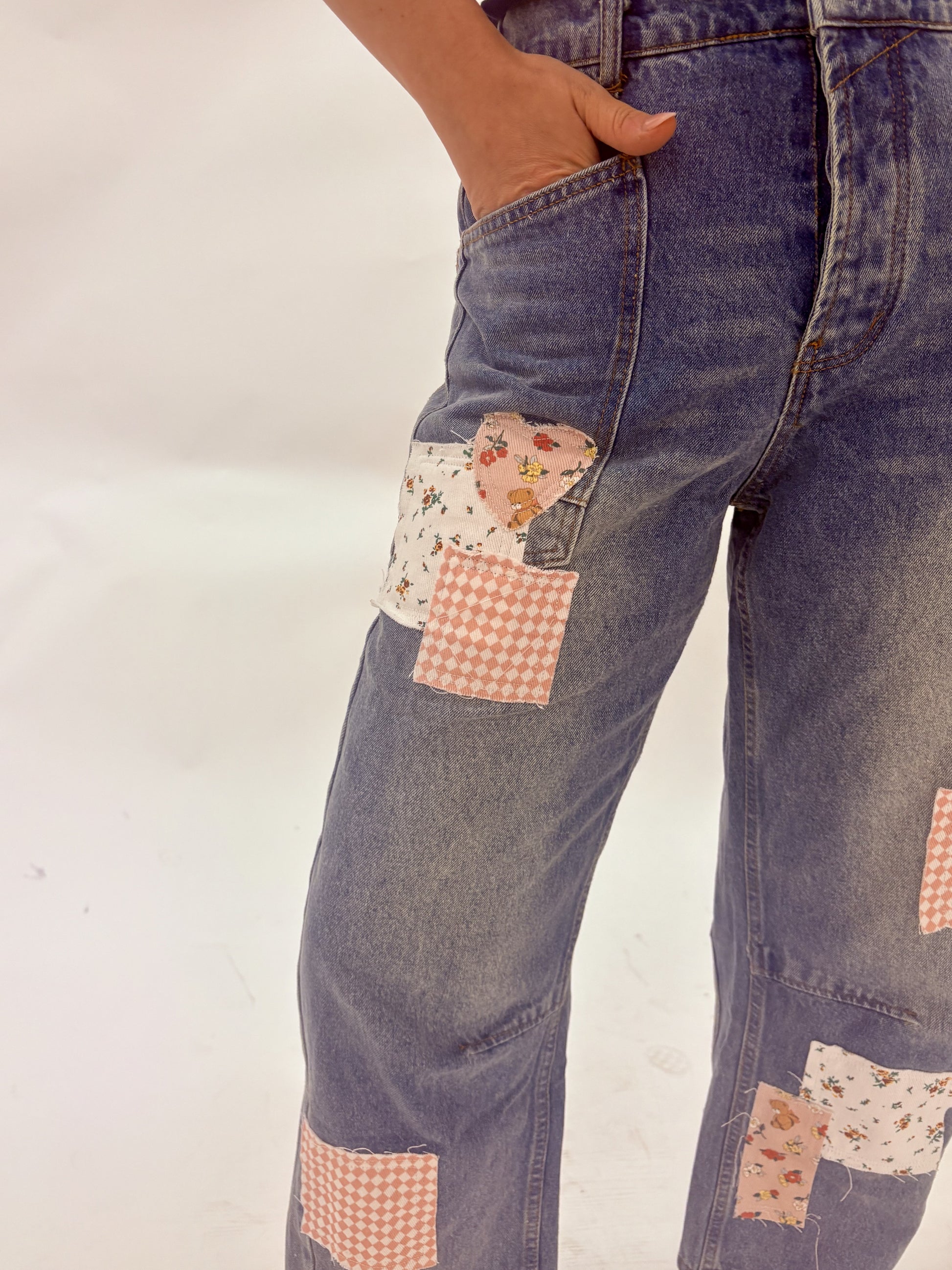 Denim pants with patchwork design on a white background