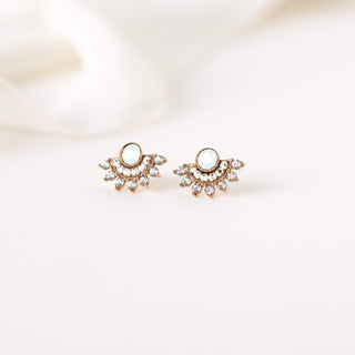 a pair of fan stud earrings on a table