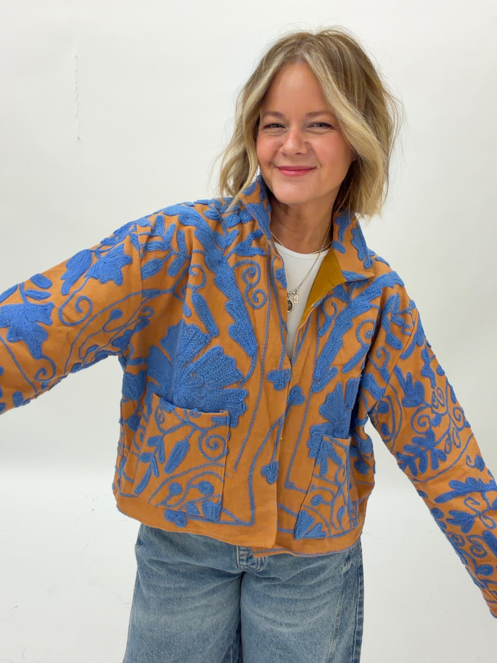 Person wearing a blue and orange patterned jacket on a white background