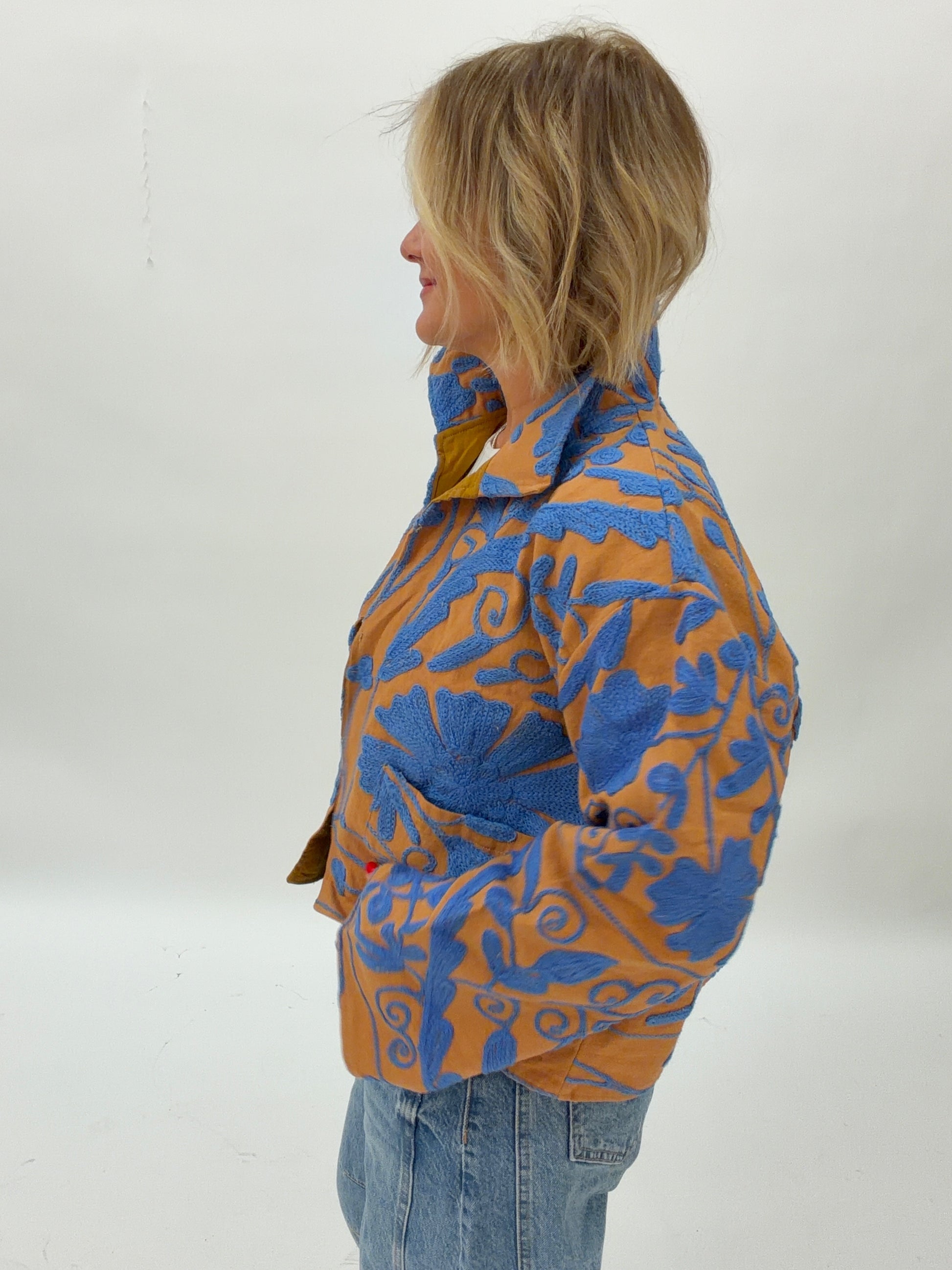 Person wearing a blue and orange patterned jacket on a white background