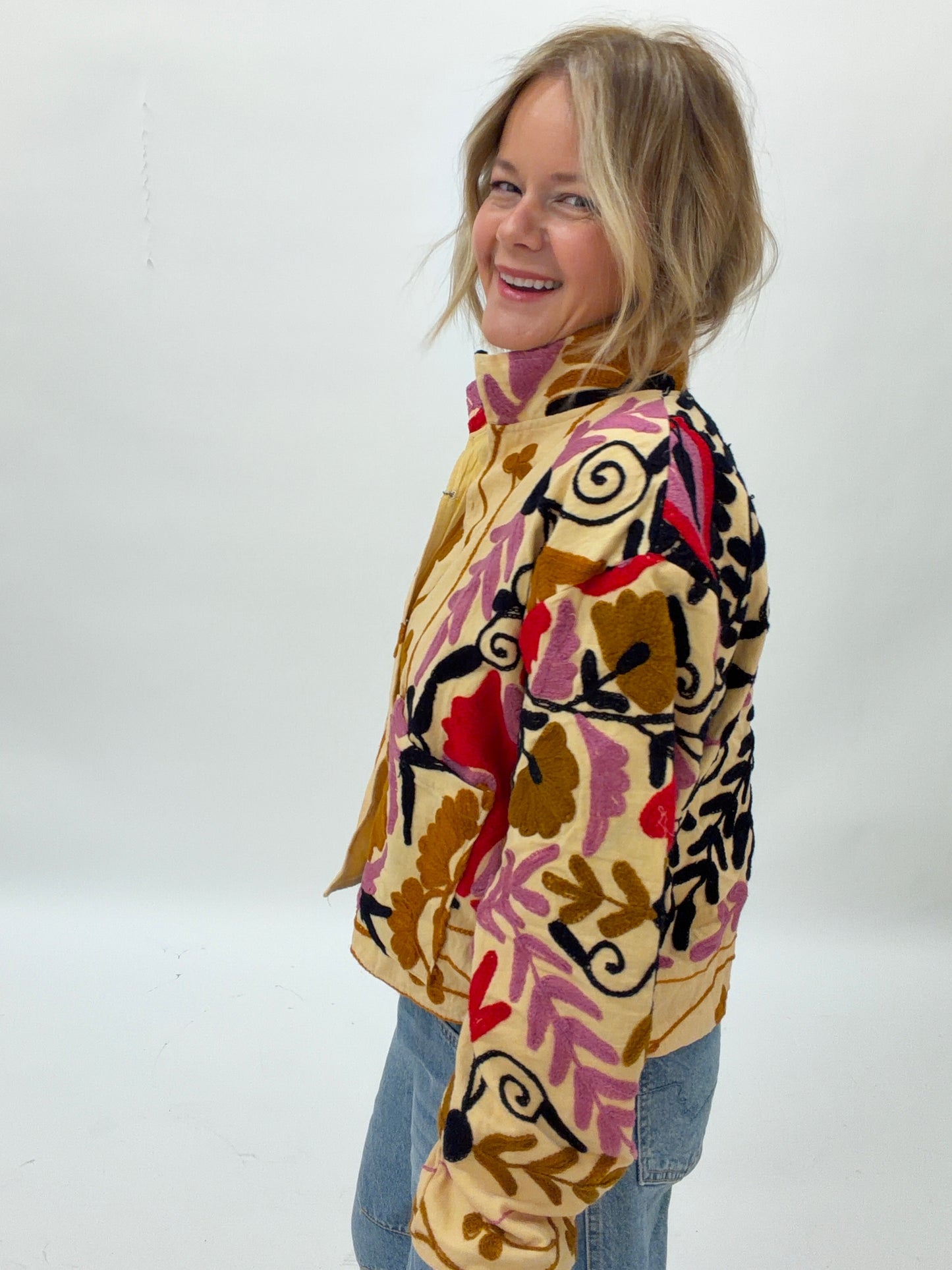 Person wearing a colorful patterned jacket on a white background