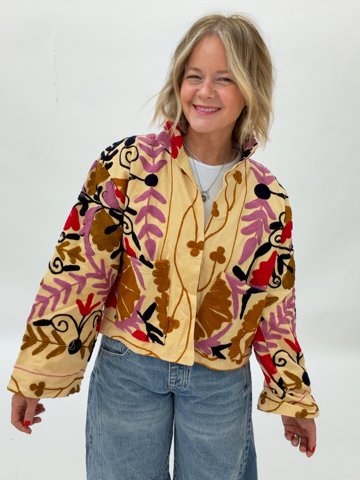 Person wearing a colorful floral-patterned jacket on a white background