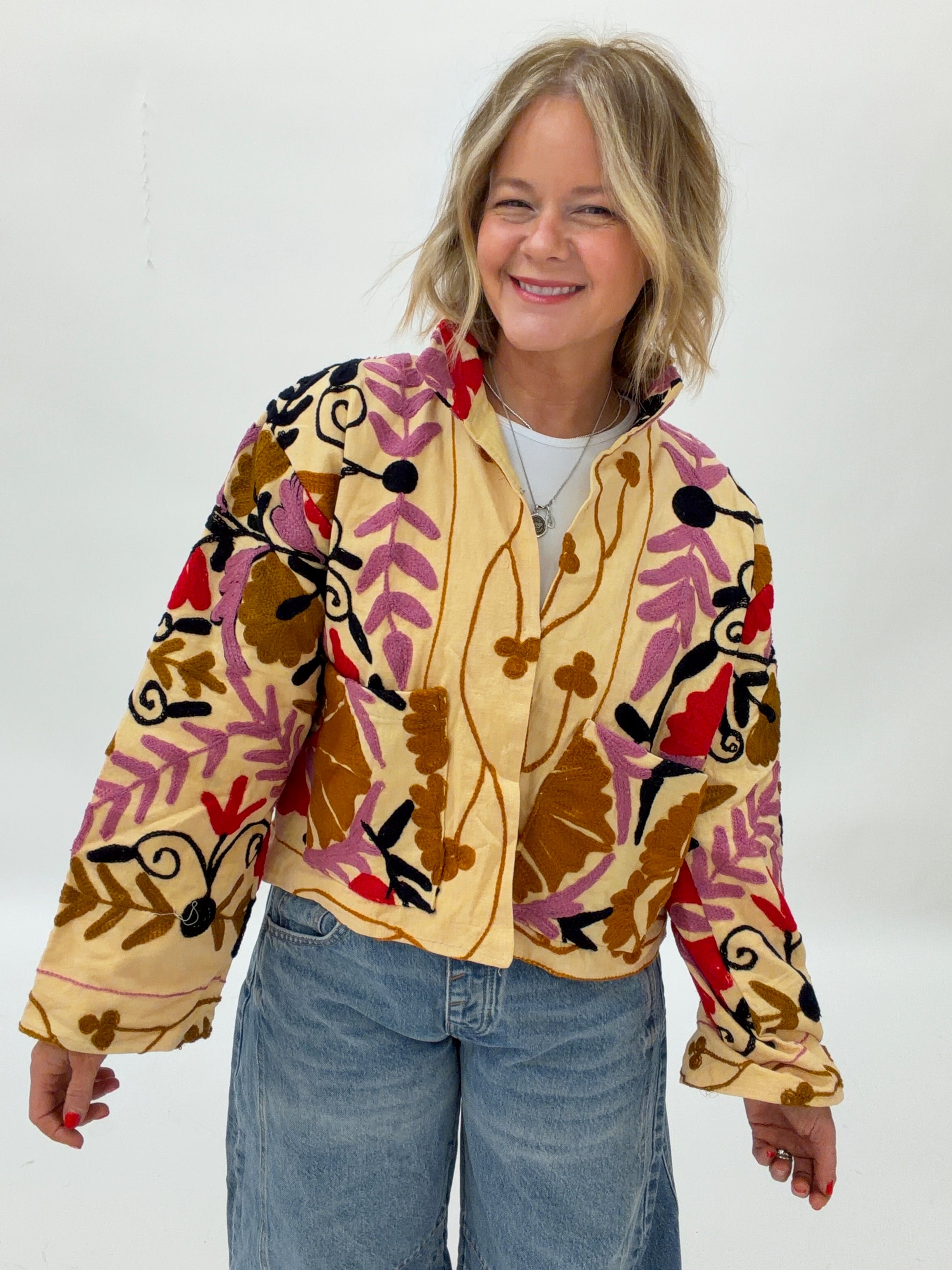 Person wearing a colorful floral-patterned jacket on a white background