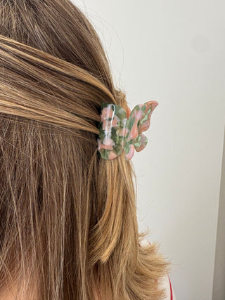 women wearing a green and pink butterfly shaped clip.