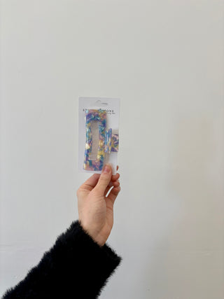 A hand holding a rectangular-shaped hair clip in a translucent green color.