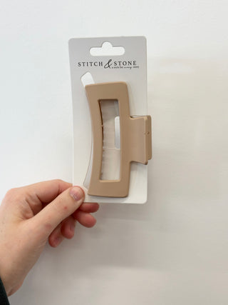 Beige fabric marker on a white card with 'Stitch & Stone' branding, held by a hand against a white background.