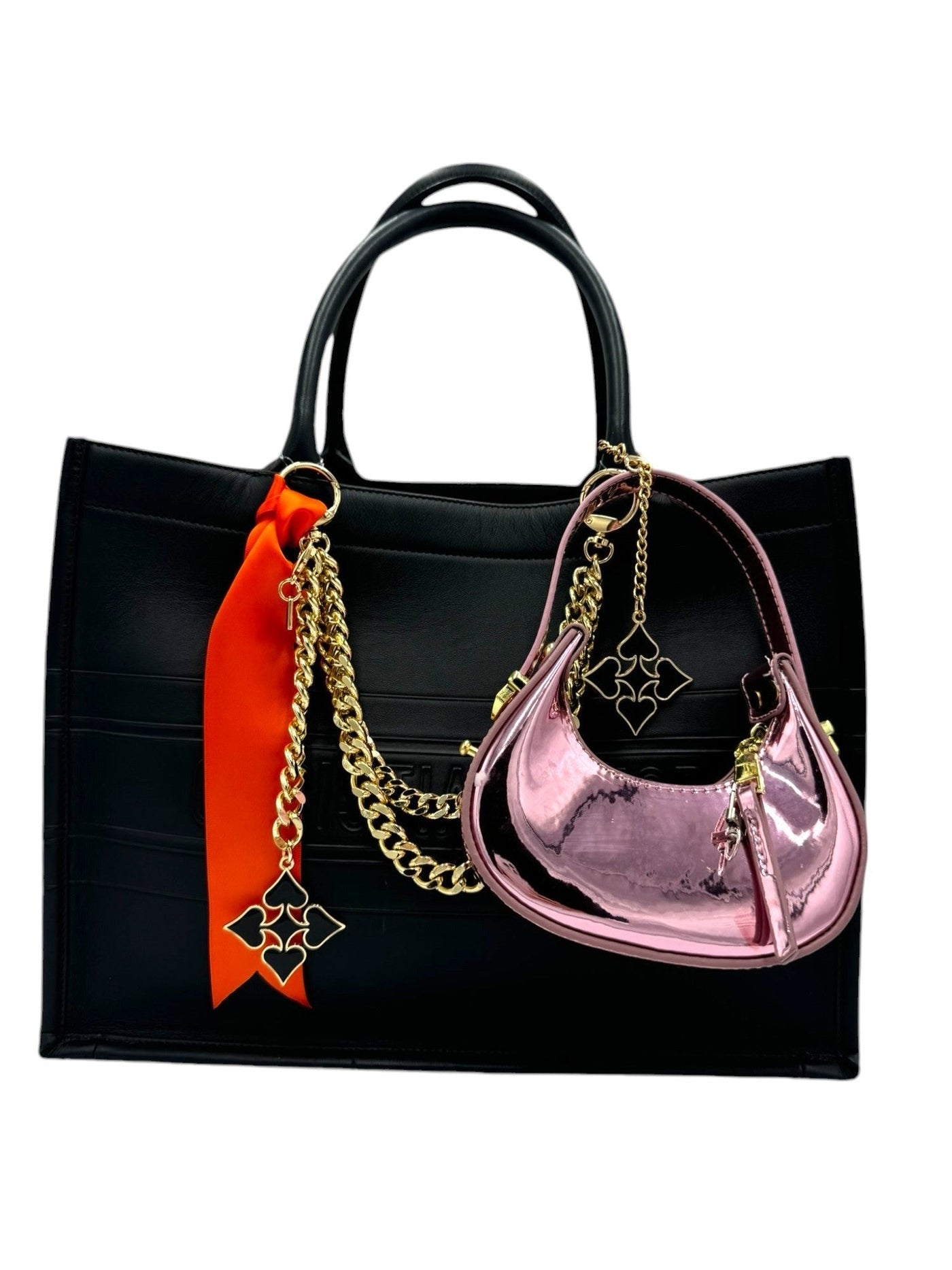 Black handbag with gold chains and colorful accessories on a white background