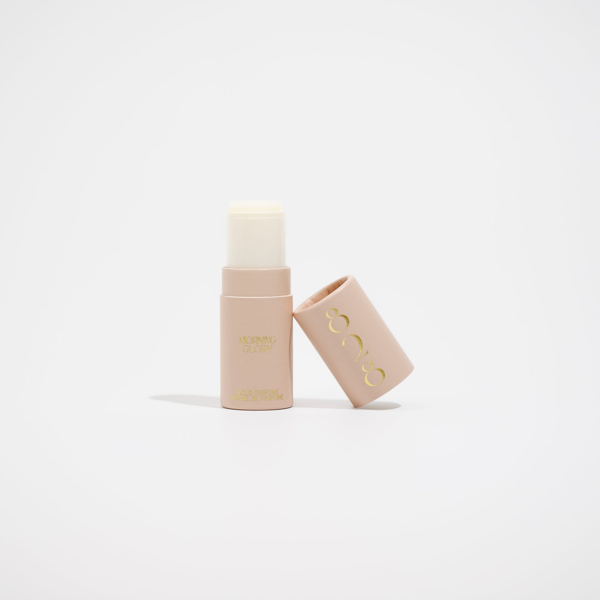 Two beige cosmetic tubes with a brand logo on a light beige background