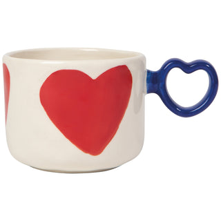 Ceramic mug with a red heart design and blue heart-shaped handle on a white background