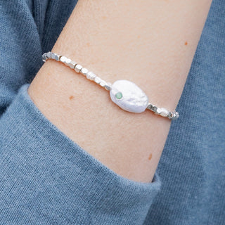 person wearing a beaded pearl bracelet