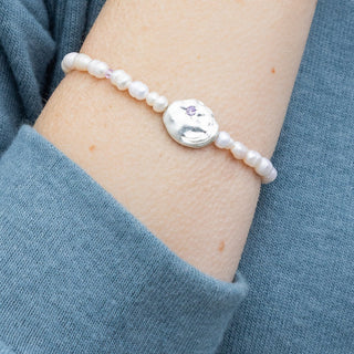 person wearing a beaded pearl bracelet