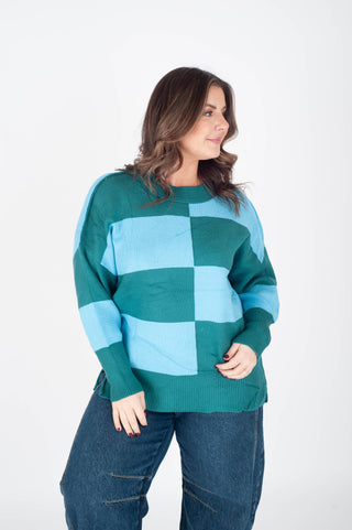 Woman wearing a green and blue checkered sweater against a white background