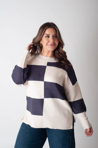 Woman wearing a checkered sweater with a plain background