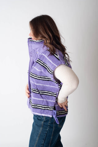 Person wearing a purple striped jacket with a white background