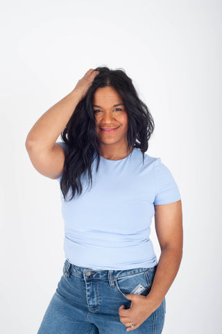 Person wearing a light blue t-shirt and jeans on a white background