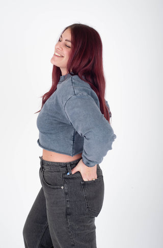 Woman wearing a blue denim jacket and black jeans on a white background