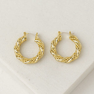 a pair of gold hoop earrings laying flat on a table