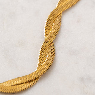 Gold chain necklace on a light gray background