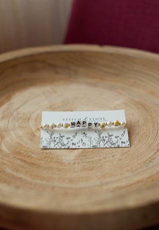 a beaded bracelet  that says happy