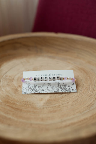 a beaded bracelet  that says self love