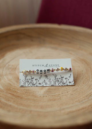 a beaded bracelet  that says grow