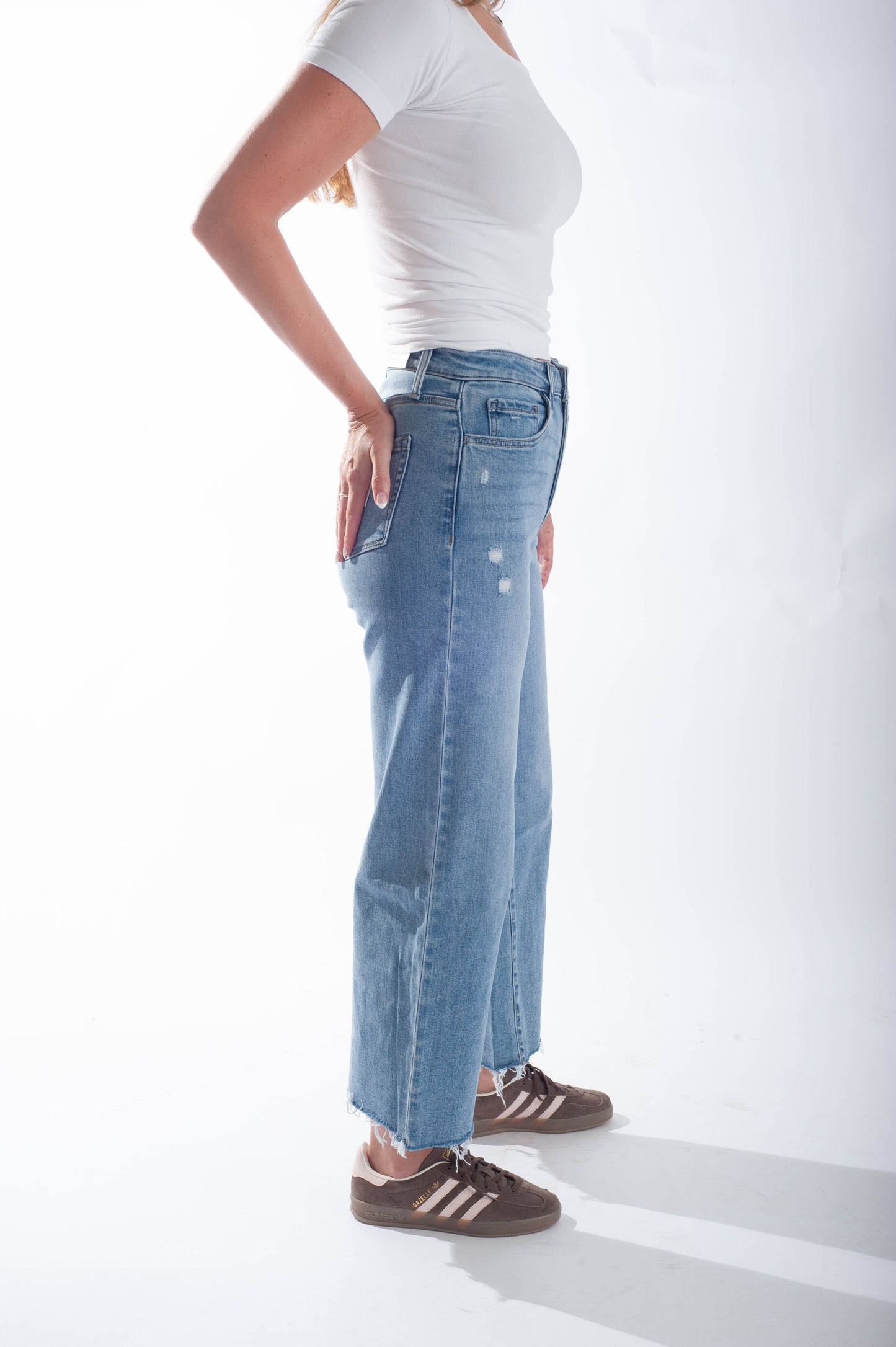 Person wearing a white t-shirt and blue jeans on a white background
